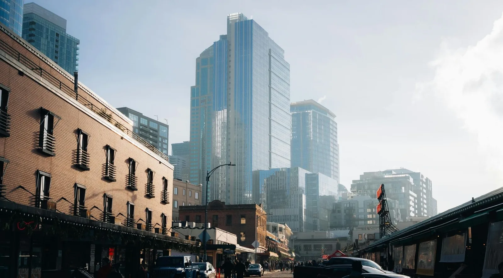 A sunny downtown Seattle street beside Pike Place Market and glass towers