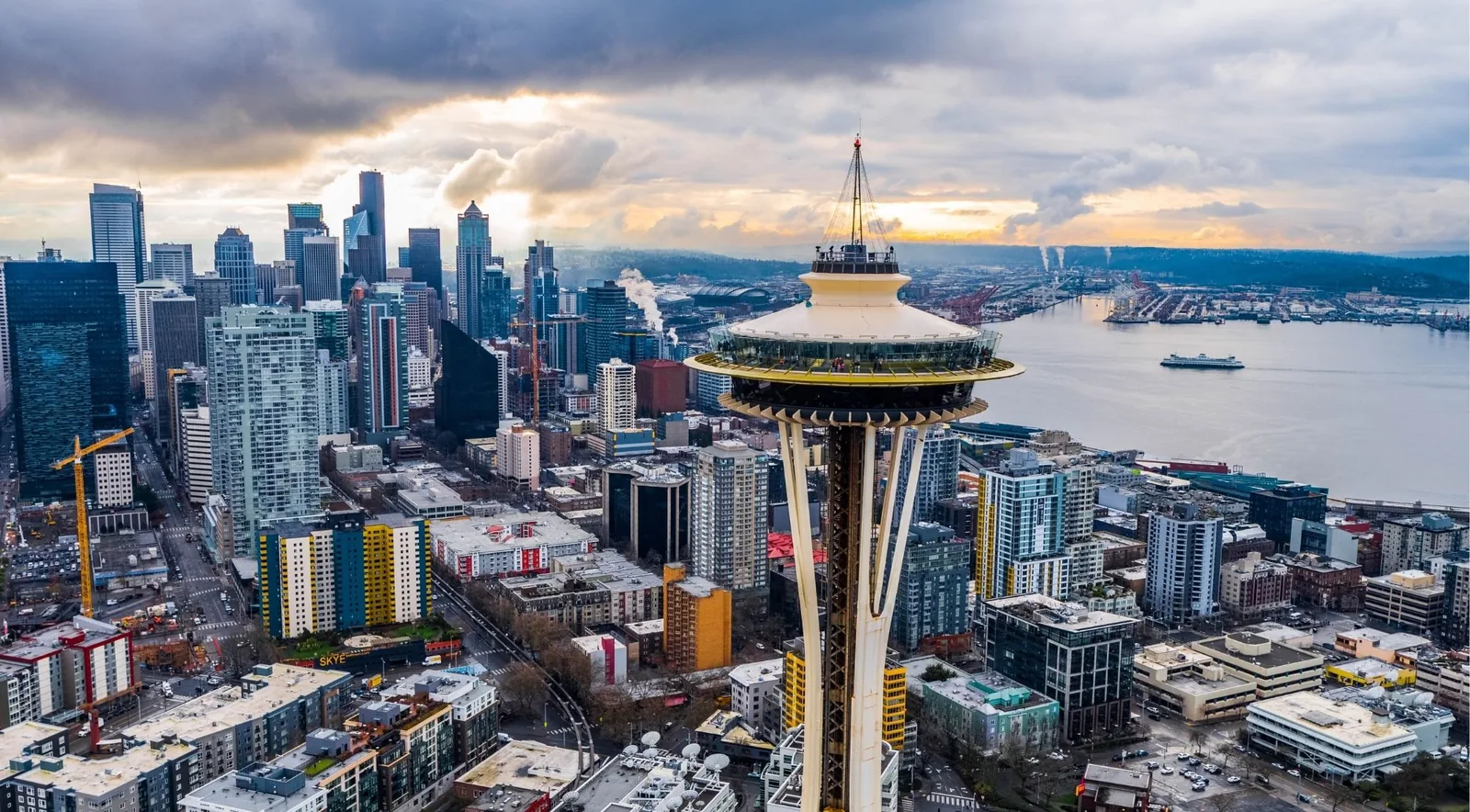 Aerial close-up of the Space Needle above the Seattle skyline and Elliott Bay